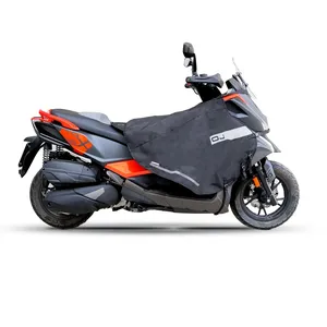 Cubrepiernas negro instalado en el lado izquierdo de una motocicleta