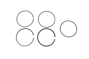 Conjunto de segmentos de pistón metálicos apilados sobre fondo neutro